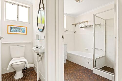 y baño con bañera, aseo y lavamanos. en 'Kangaroo Corner' Coastal Charm & Midcentury Flair, en Sídney