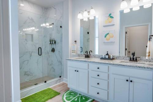 a white bathroom with two sinks and a shower at Citrus Cottage: Comfy - Hwy 10 - Peaceful Retreat in Tallahassee