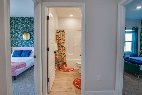 a bedroom with a bed and a bathroom with a tub at Citrus Cottage: Comfy - Hwy 10 - Peaceful Retreat in Tallahassee