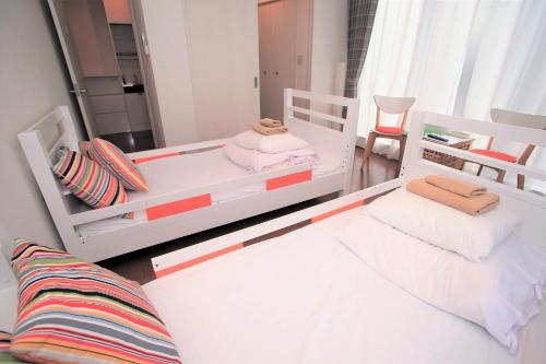 een slaapkamer met 2 bedden en een spiegel bij Numero Uno Tokyo - Vacation STAY 25720v in Tokyo