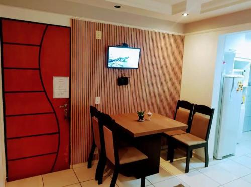 uma sala de jantar com uma mesa e uma televisão na parede em CantinhoDaAline2-Expo-Aeroporto-18981391712 em Araçatuba