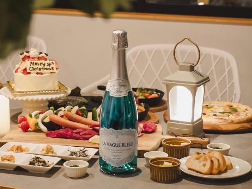 a bottle of champagne sitting on a table with food at Setouchi Island Stays Suo Oshima in Suo Oshima