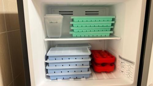 a refrigerator filled with plastic containers and other items at PandaHomestay28 in Skudai