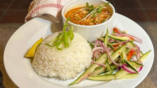a plate of food with rice and a bowl of soup at Sonrisa Boutique Hotel - Adults Only in Kralendijk