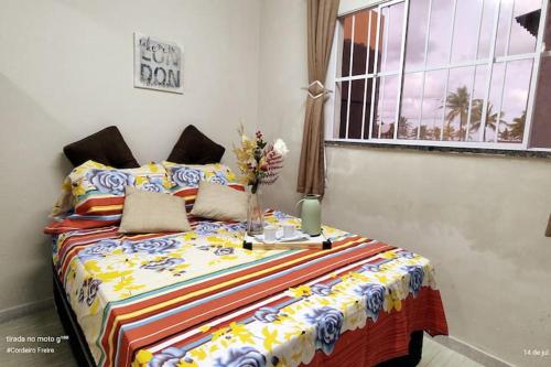 a bedroom with a bed with a colorful blanket at Oceano Azul Hospedagens a 50 M DA ORLA-Passarela do Caranguejo in Aracaju