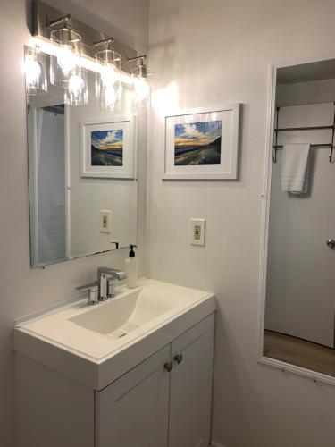 San Dune Inn في مانزانيتا: حمام أبيض مع حوض ومرآة
