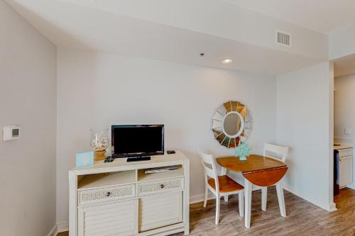 a room with a desk with a television and a table with chairs at Luau 6834 in Destin