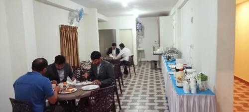 a group of people sitting at tables in a restaurant at The Nisarga Residency in Bangalore