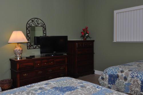 a bedroom with a dresser with a television and a mirror at Beachfront Bliss Absolute Gulf Front 2 Bedroom Condo in Navarre