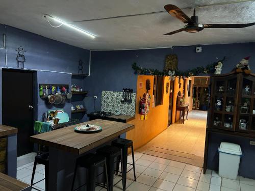 a kitchen with a wooden table and a blue wall at Hostel Casa Xtakay in Valladolid