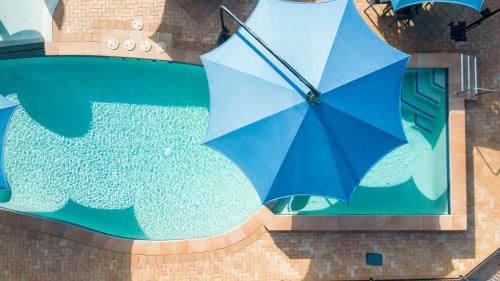 a blue umbrella in front of a swimming pool at Ingenia Holidays Hervey Bay in Hervey Bay