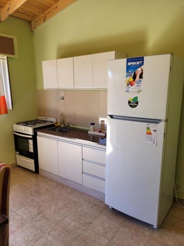 a kitchen with a white refrigerator and a stove at ALQUILERES MARLUZ in Trelew