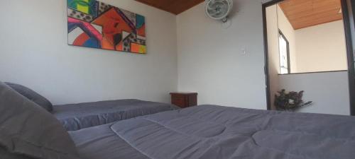 1 dormitorio con 1 cama y una pintura en la pared en Hermoso apartamento Duplex, en Guaduas