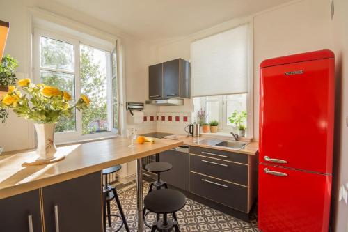 - un réfrigérateur rouge dans la cuisine avec un comptoir dans l'établissement Isabelle's And Christian's 2 Bedroom Flat Mcon, à Mâcon
