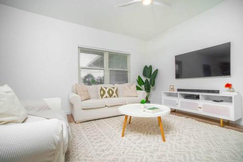 Una sala de estar blanca con un sofá y una mesa. en Tamarind Bay Unit # 22, en Dog City