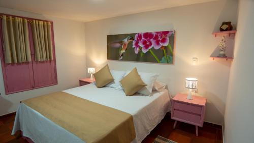 1 dormitorio con 1 cama y una pintura en la pared en BALCÓN DEL CIELO eco hotel glamping en Frailes