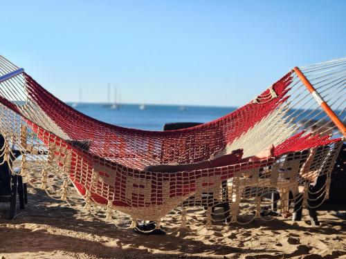 een hangmat op het strand met de oceaan op de achtergrond bij Hotel La Palapa in Tamarindo