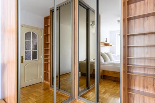 eine Glasschiebetür in einem Schlafzimmer in der Unterkunft Bella Casa Premium Apartment - Biesiadna - Warszawa in Warschau