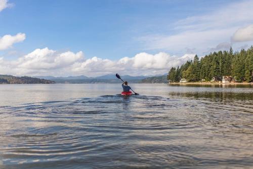 a person is paddling a canoe on a lake at Les Chalets Baie Cascouia in Lac Kénogami