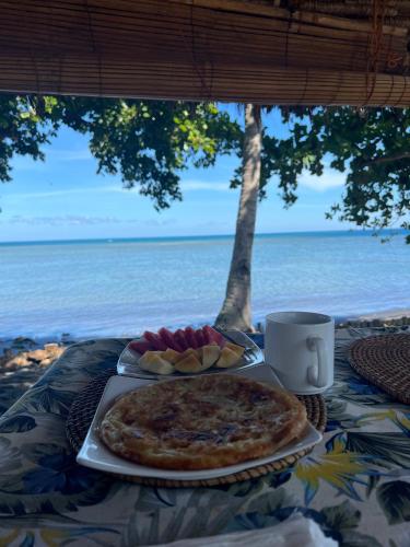 een tafel met een pizza en een kopje koffie bij Rinjani Beach Eco Resort in Tanjung