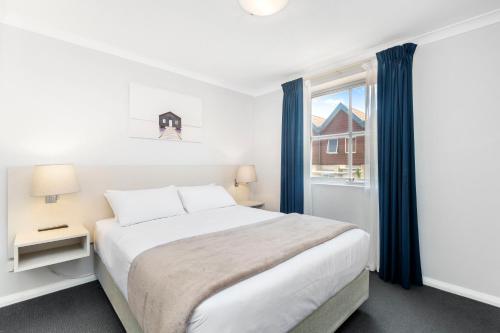 a bedroom with a large bed and a window at Nautica Residences Hillarys in Perth