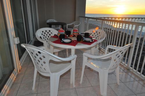 a white table and chairs on a balcony with the ocean at Beachfront Bliss Absolute Gulf Front 2 Bedroom Condo in Navarre