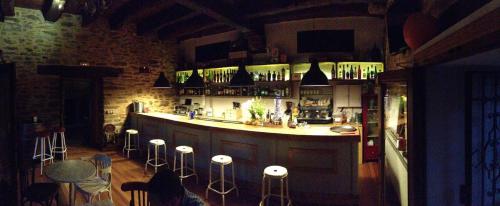 a bar in a room with stools around it at La Hoja de Roble in Puebla de Sanabria