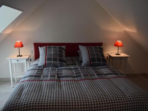 ein Schlafzimmer mit einem Bett mit zwei Lampen an zwei Tischen in der Unterkunft Gîte Neuilly-le-Vendin, 3 pièces, 4 personnes - FR-1-600-131 in Neuilly-le-Vendin