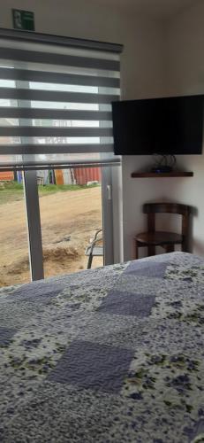 ein Schlafzimmer mit Bett und Blick auf ein Feld in der Unterkunft Cabañas Campestres Altos de Leñadura Punta Arenas in Punta Arenas