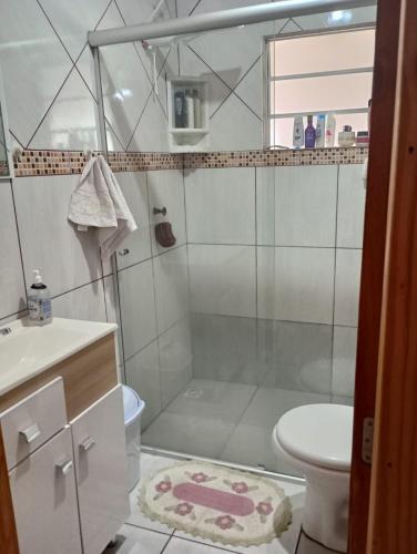 uma casa de banho com um chuveiro, um WC e um lavatório. em Aconchego em Pântano Grande