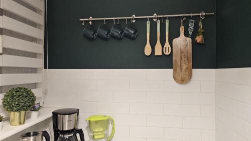 a kitchen with utensils hanging on a wall at Apartament Zielona Przystań Gdańsk in Gdańsk