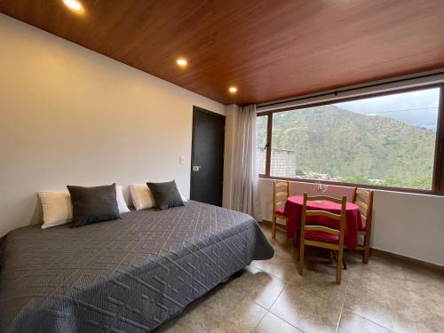 Schlafzimmer mit einem Bett, einem Tisch und einem Fenster in der Unterkunft Pine Hill apartment 1 bedroom 1 bathroom in Baños