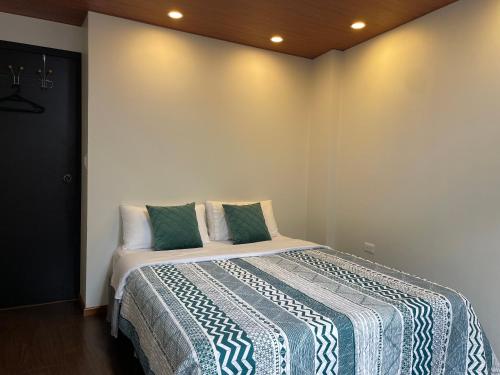 ein Schlafzimmer mit einem Bett mit einer blauen und weißen Decke in der Unterkunft Pine Hill apartment 1 bedroom 1 bathroom in Baños