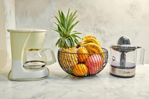una cesta de fruta en un mostrador con una licuadora en fleur de tranquillité, en Le Gosier