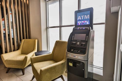 an atm machine in a hospital room with two chairs at Holiday Inn Express Toronto-North York by IHG in Toronto