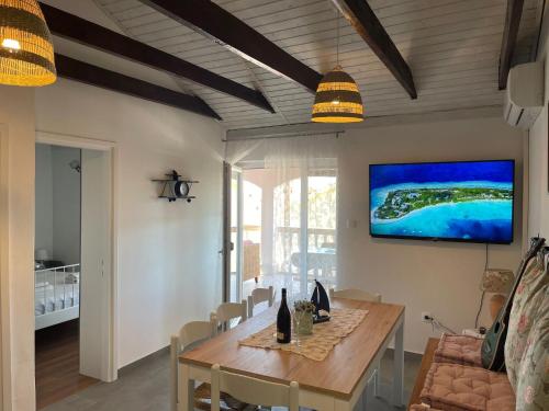 a dining room with a table and a tv on the wall at Apartments with parking space Privlaka, Zadar - 21749 in Privlaka