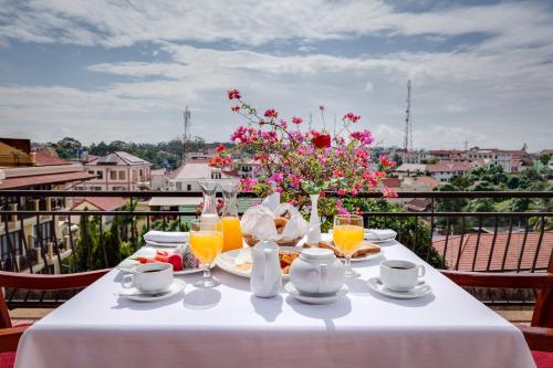 a table with food and drinks and flowers on a balcony at Angkor Paradise Hotel in Siem Reap
