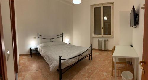 1 dormitorio con cama, mesa y ventana en Daniele rooms en Arezzo