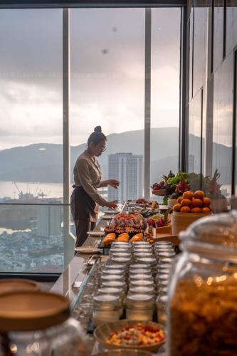 a man standing in front of a buffet of food at Grand Hyams Hotel - Quy Nhon Beach in Quy Nhon