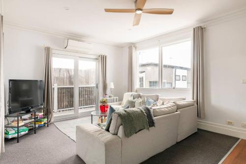 a living room with a couch and a flat screen tv at Urban Elegance apartment in Yarraville village in Yarraville