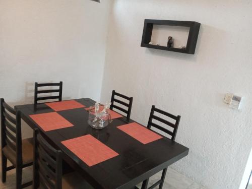 a black table with four chairs and a mirror on the wall at El Mirador Holbox in Holbox Island