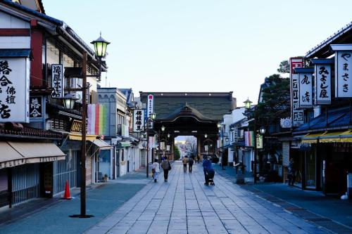 a group of people walking down a street at 信州善光寺 薬王院 in Nagano