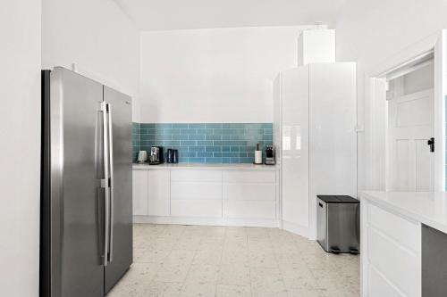 a stainless steel refrigerator in a white kitchen at Pipers Rest in Yarrawonga