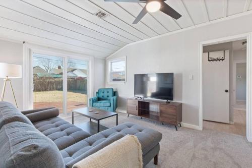 a living room with a couch and a flat screen tv at Tulsa Vintage Chic Cottage - King Bed Expo, TU, Dtwn in Tulsa