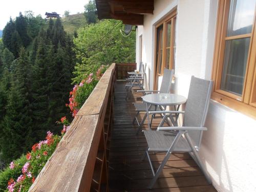 a row of chairs and tables on a balcony at Bauernhof Bachgut in Mühlbach am Hochkönig