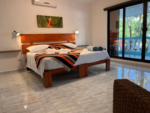 a bedroom with a bed with a wooden headboard at Casa Puerto Morelos in Puerto Morelos