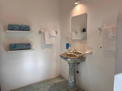 a bathroom with a sink and a mirror and towels at Casa Puerto Morelos in Puerto Morelos