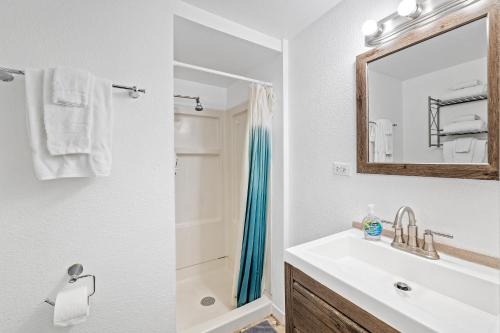 ein Bad mit einem Waschbecken, einem Spiegel und einer Dusche in der Unterkunft soulfactory Hawaii in Honolulu
