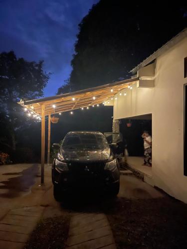 a car parked under a pergola with lights on it at Eucalyptus Cabin Boquete in Bajo Boquete