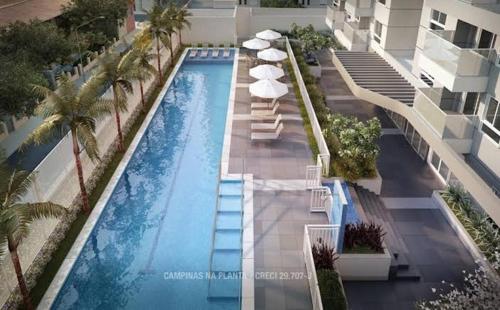 uma vista sobre uma piscina com guarda-sóis e palmeiras em Ap smart Campinas em Campinas